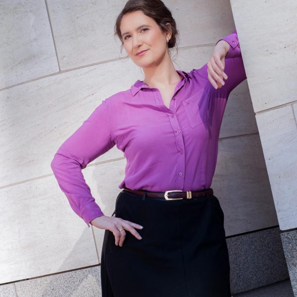 Portraitfoto einer Unternehmerin im Businessoutfit, stehend an einer Aussenwand des Deutschen Historischen Museums
