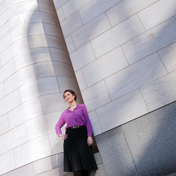 Portraitfoto einer Unternehmerin im Businessoutfit, stehend an einer Aussenwand des Deutschen Historischen Museums