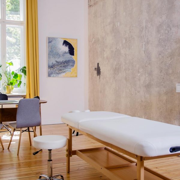 Interieurfoto einer physiotherapeutischen Praxis mit Schreibtisch und Massagetisch