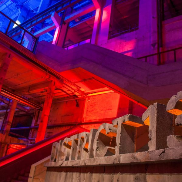 Event- und Veranstaltungsfotos in Berlin - Interieurfoto einer mit roten und blauen Effektlichtern beleuchteten Fabrikhalle
