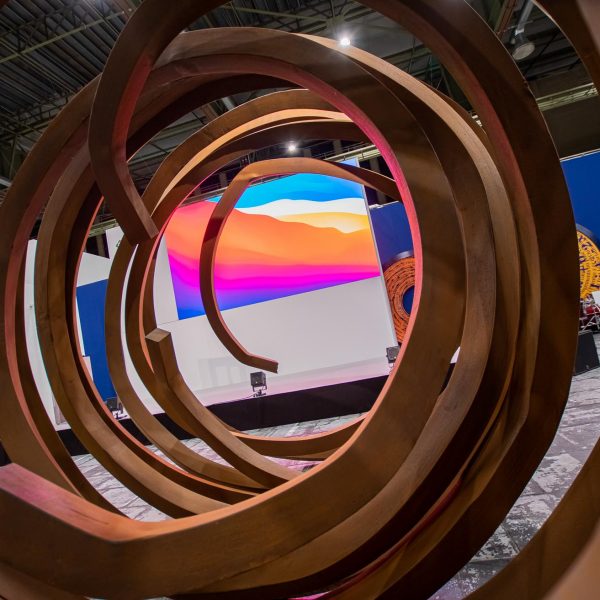 Event- und Veranstaltungsfotos in Berlin - Imagefoto einer überdimensionalen, spiralförmigen Skulptur, durch welche man eine Bühne und LED Wand sehen kann