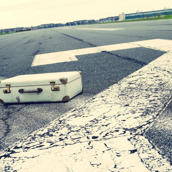 Imagefoto eines alten Reisekoffers, der auf der Startbahn des Tempelhofer Flugfelds liegt